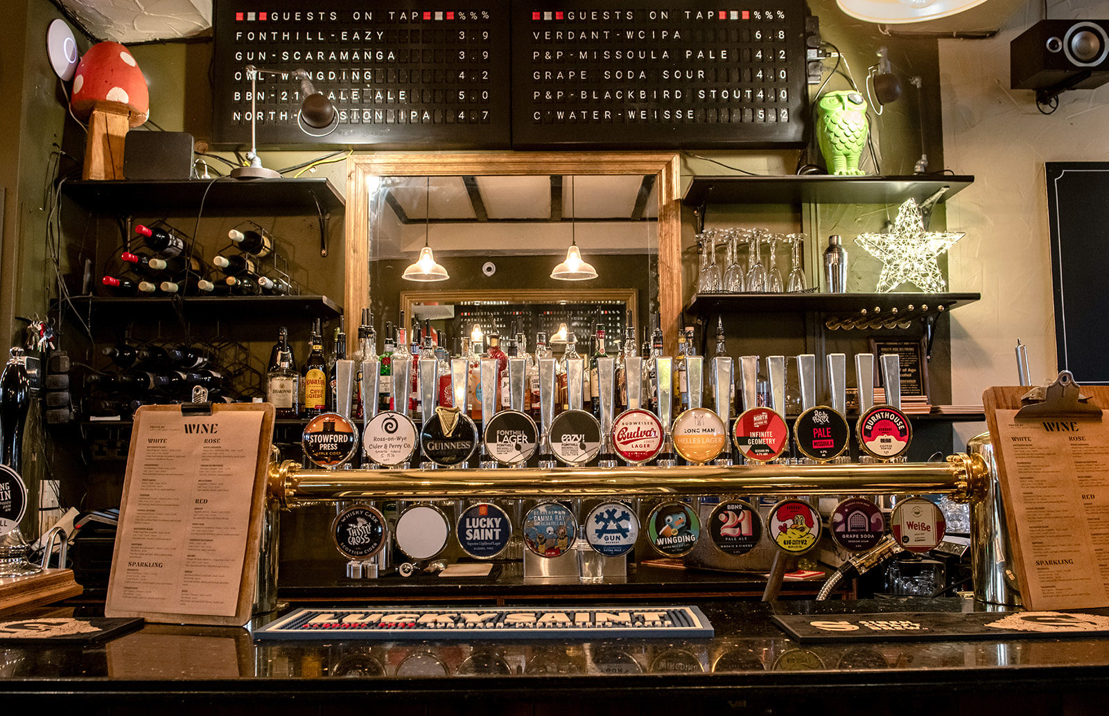 The Ragged Trousers bar, stocked with wine bottles, and displaying twenty-two draught lines showcasing a range of beers, ciders, and real ale.